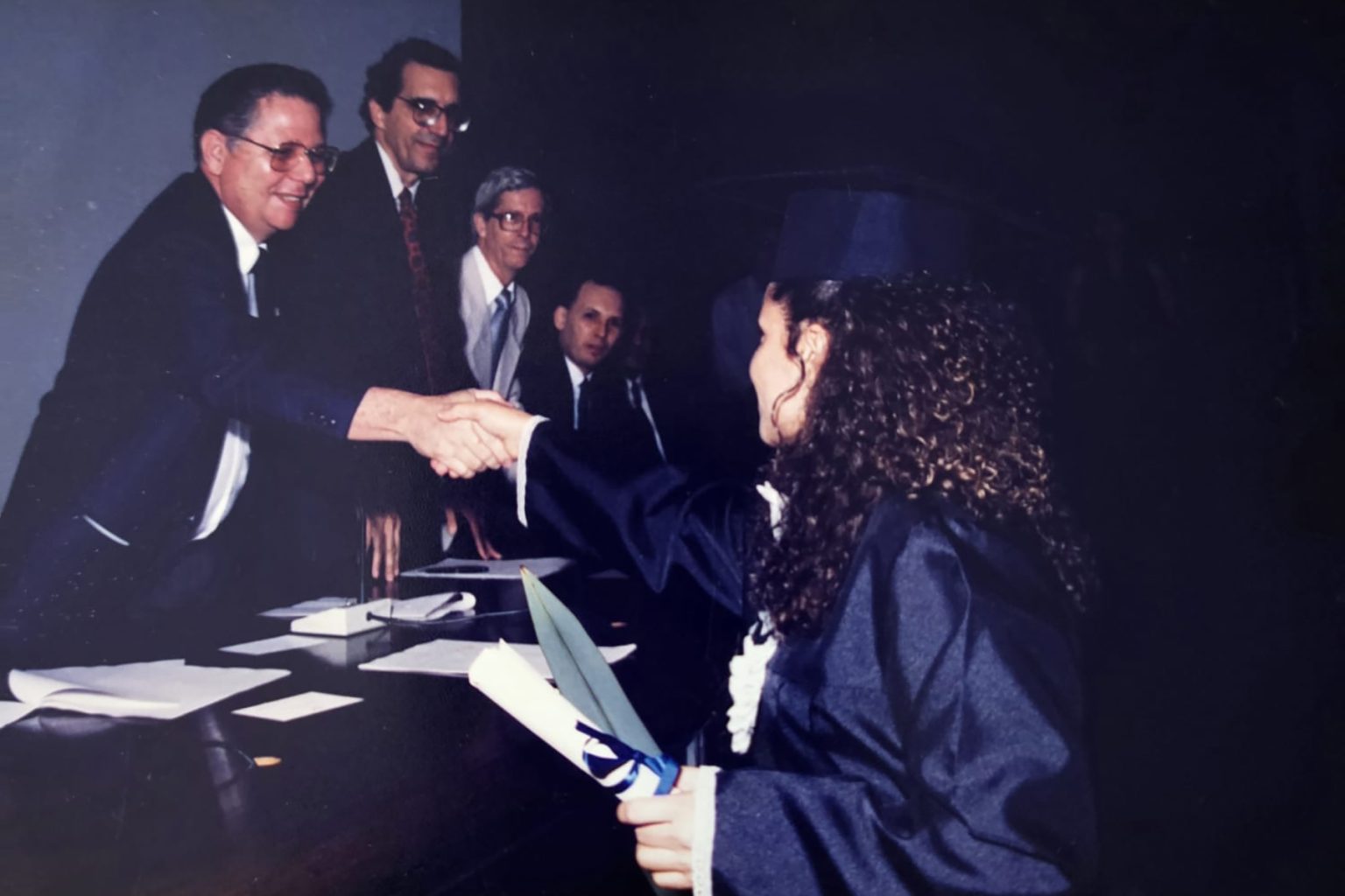 Formanda Maria Cícera cumprimentando os componentes da mesa, Prof. Lauro Morhy, Reitor, Prof. Murilo Cunha, Prof. Sebastião Souza e Prof. Marcílio de Brito. Turma 2/1994. Acervo pessoal de Maria Cícera da Silva.